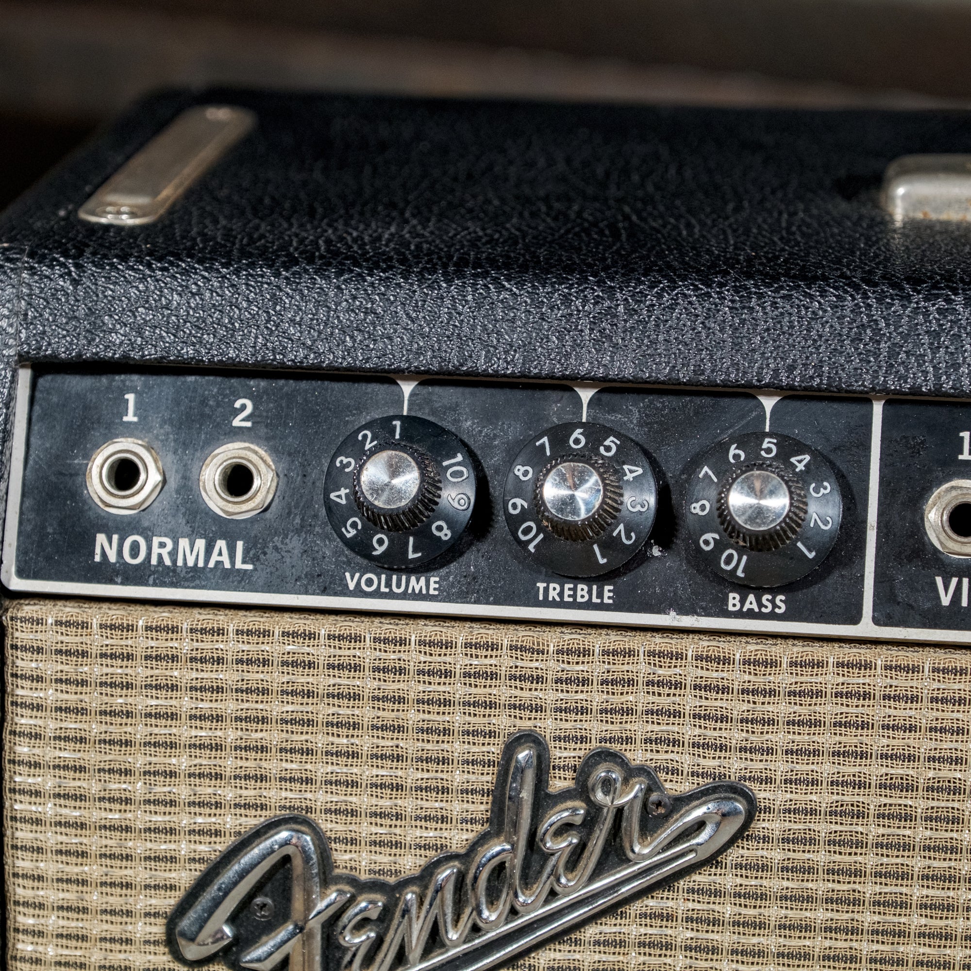 The silver-capped volume knob and numbered skirt on a vintage Fender Deluxe Reverb amplifier